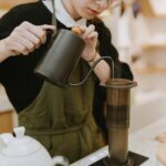 Barista menuangkan air panas ke alat seduh kopi Aeropress