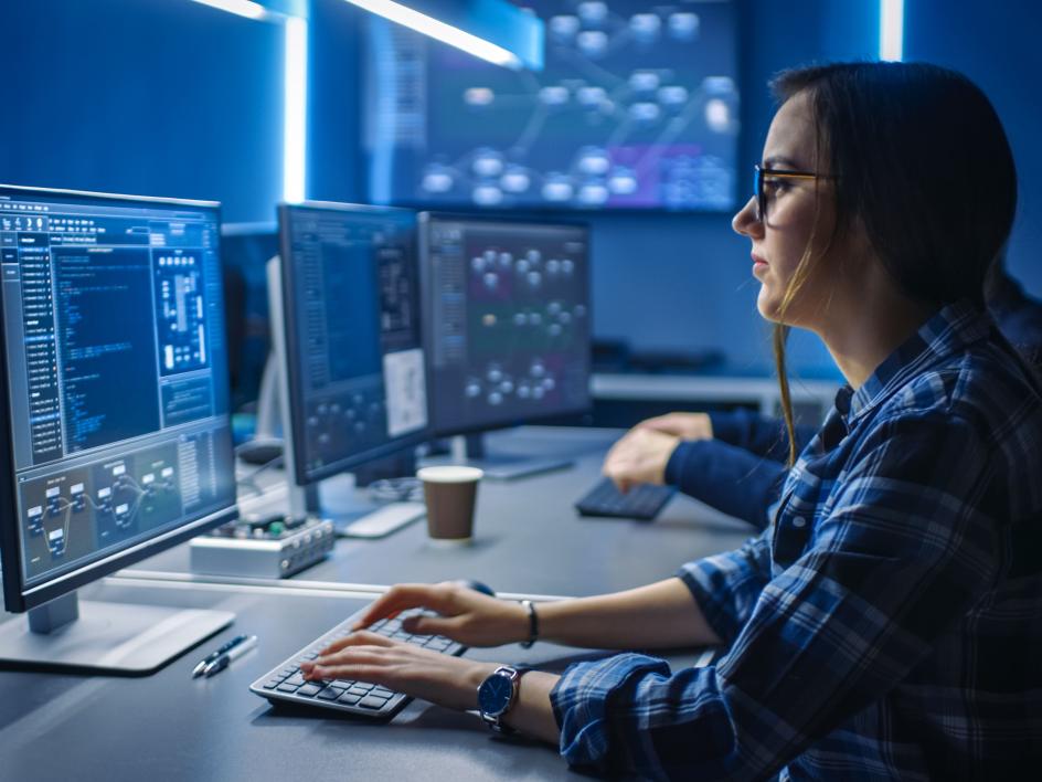 Programmer wanita sedang bekerja di depan monitor.