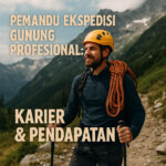 Seorang pemandu gunung profesional berdiri di jalur pendakian dengan perlengkapan lengkap.